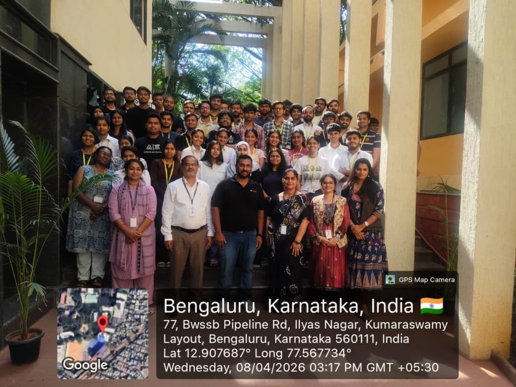 Large group photo on outdoor steps at an institutional event in Bengaluru